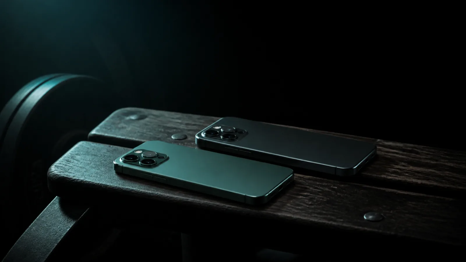 Two phones face down on a wooden gym bench, one slightly ahead of the other.